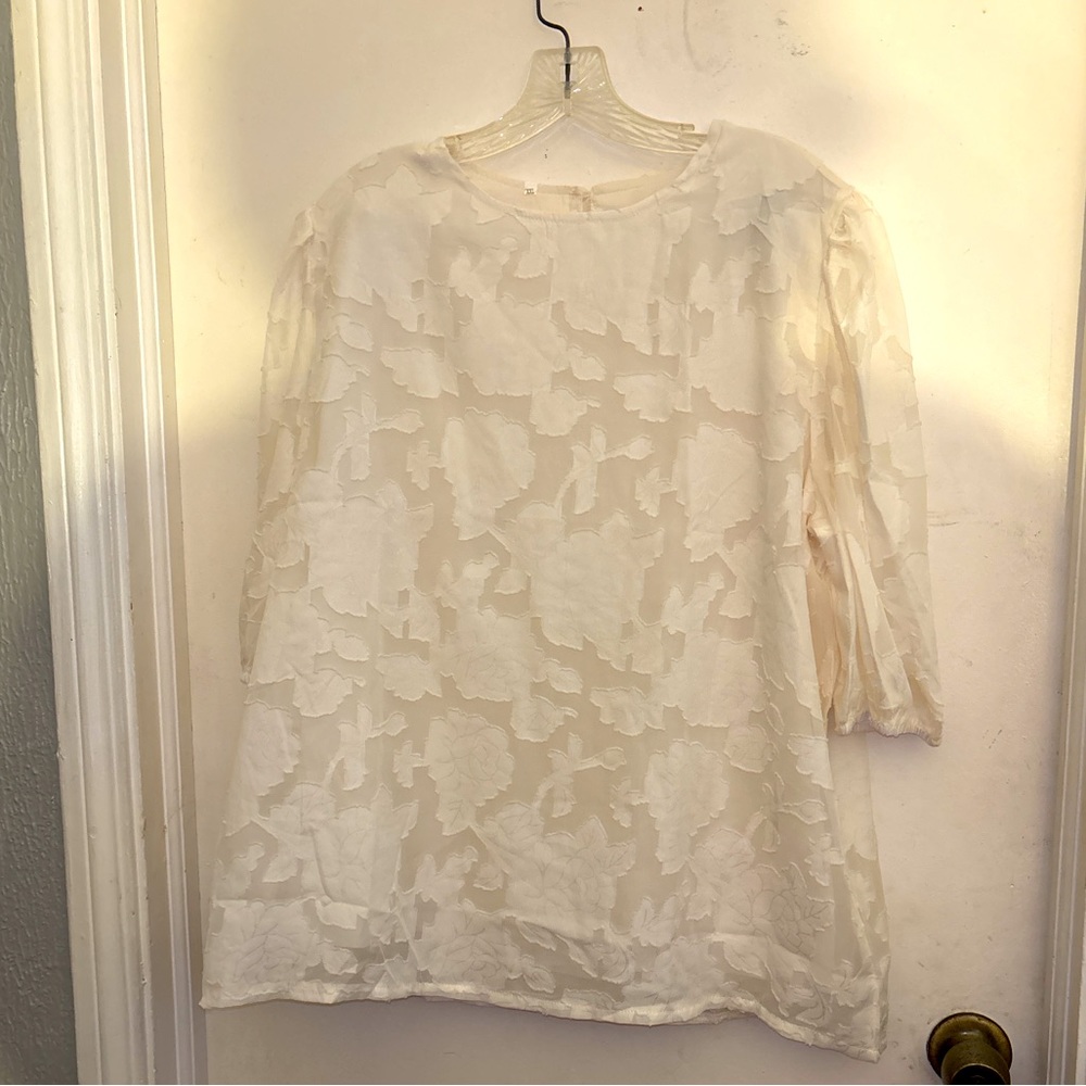 Zulily top in XXL has embossed flowers It’s  lining the sleeve are see-threw